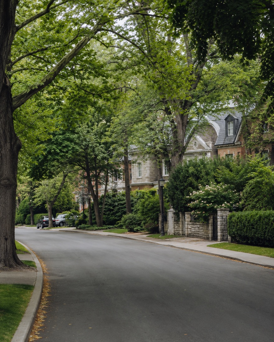 Rosedale, Toronto — heritage stone mansion behind a stone garden wall on a tree-canopied street